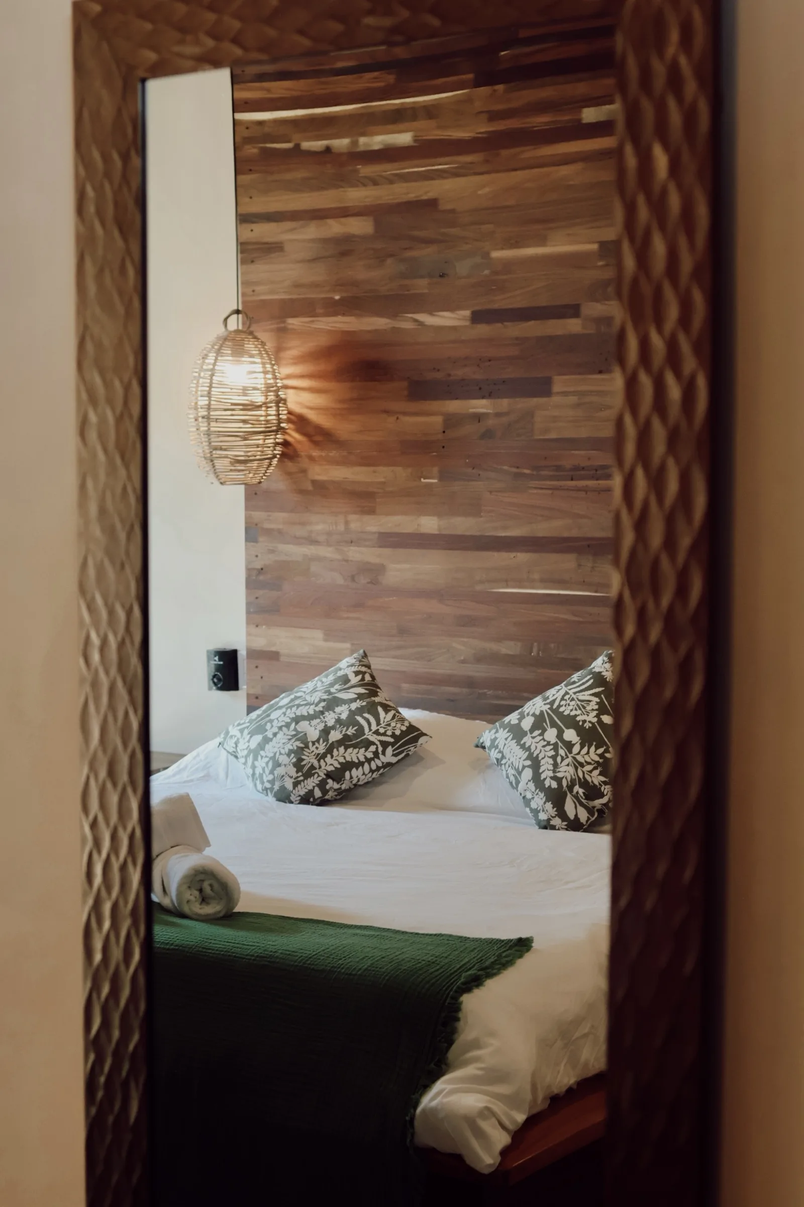 Baño rústico con muros texturizados, espejo redondo y lavabo blanco